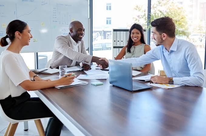 Business partners shaking hands across a meeting table